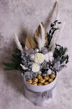 a white box filled with silver and gold decorations