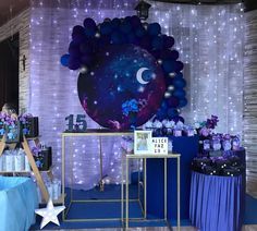 a purple and blue themed birthday party with balloons, stars, and moon on the wall