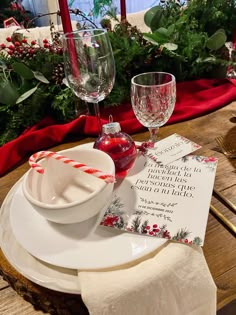 a place setting with napkins, wine glass and candy cane on the table top