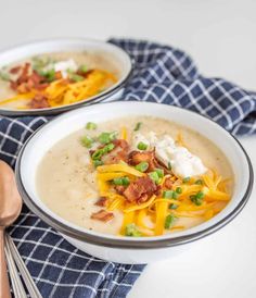 two bowls of soup with cheese and bacon