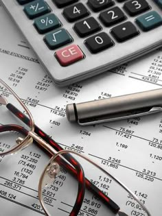 eyeglasses and calculator on top of financial documents