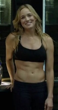 a woman standing in front of a counter top with her hands on her hips and smiling at the camera