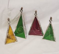 three triangular stained glass ornaments on a white background