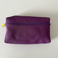 there is a purple bag with the word mandarina duck on it's side