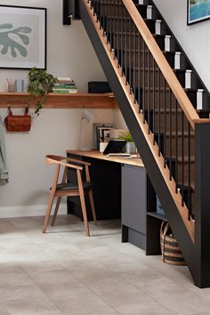 the stairs in this home are made of wood and black metal, with a desk underneath them