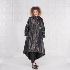 "Black Raincoat Women, Cyberpunk Rain Jacket, Hooded Cape Coat This cyberpunk rain jacket has an asymmetrical design longer on the back and shorter on the front. It has long double side zipper along with two side pockets and long belt to adjust the waistline to your personal needs and fashion style. The elastic finishes on the sleeve and the light fabric make this rain coat a \"must have\" fashion piece for the season. The model in the picture is 168cm. ⅼ 5.6 ft. tall and is wearing size S / col Hooded Raincoat For Rainy Season, Hooded Parka For Rainy Weather With Double-lined Hood, Hooded Parka For Rainy Fall Weather, Fall Hooded Parka For Rainy Weather, Fall Hooded Raincoat With Detachable Hood, Rainy Season Hooded Raincoat With Double-lined Hood, Oversized Hooded Raincoat For Rainy Season, Long Rainy Season Coat For Rainy Weather, Double-lined Hood Parka For Rainy Season