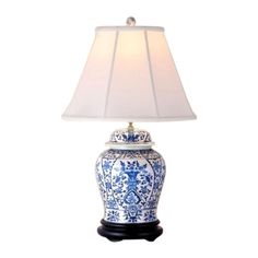 a blue and white lamp with a light shade on it's base is shown