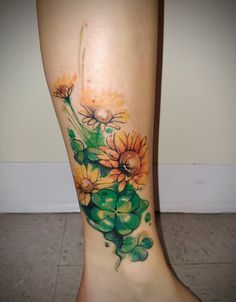 a woman's leg with flowers and watercolors on the bottom of it