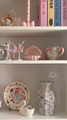 the shelves are filled with china and other decorative items in pink, white, and blue