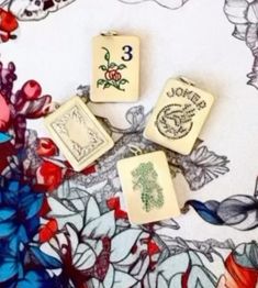 four stamps are sitting on top of a flowered tablecloth, with the number three printed on them