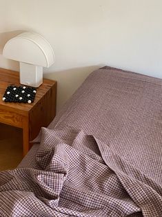 a bed sitting next to a wooden night stand