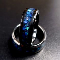 "This is the Sapphire Storm Ring, made with Sapphire and Cobalt Blue Opal on a black blue background. Meant to be the counter to the Lava Rock Ring, everything is the opposite from the colors to the glow being blue. The Sapphire adds depth to the ring while the Opal takes center stage with its different blue/green hues and flashes The ring will come in your choice of either a Tungsten-Carbide or Black Ceramic (titanium carbide) band. Both bands are extremely durable and scratch resistant, being Formal Blue Opal Rings, Blue Opal Rings For Anniversary, Blue Opal Anniversary Rings, Blue Opal Jewelry For Wedding, Glow In The Dark Wedding, 5 And Below, Black And Blue Background, Rock Ring, Wedding Band For Men