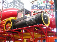 the inside of a play center with many different types of toys on display and signs in the background