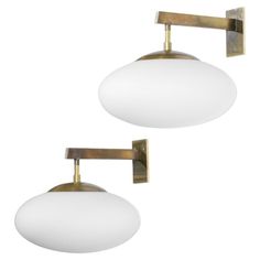 two lights that are on the side of a wall mounted light fixture, one white and one gold