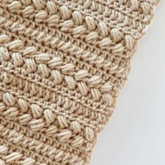 a crocheted blanket is shown on a white surface