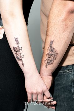 two people holding hands with tattoos on their arms