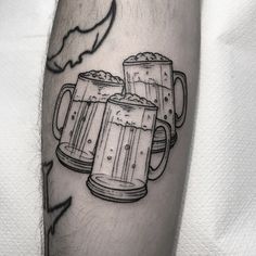 a man's leg with three mugs of beer on it