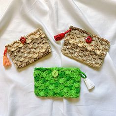 three small purses sitting on top of a white sheet