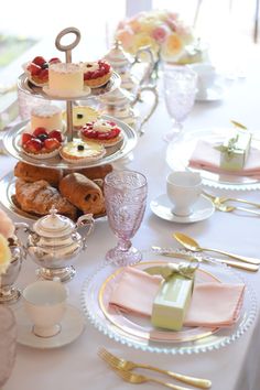 the table is set with many different types of pastries and desserts on it