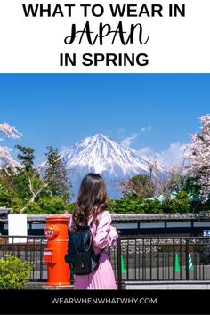 a woman standing in front of a mountain with the words what to wear in japan in spring