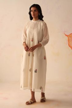 Ivory chanderi dress with side pockets and 3D flowers hand embroidery. Comes with a cotton mul slip. - Aza Fashions White Bohemian Dress With Cutdana, Bohemian Cotton Silk Wedding Dress, Cream Embroidered Chanderi Dress, Embroidered Chanderi Cream Dress, White Anarkali Dress In Cotton Silk, Embroidered Cream Chanderi Dress, Traditional White Chanderi Embroidered Dress, Traditional White Embroidered Chanderi Dress, Off White Embroidered Chanderi Dress