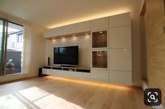 an empty living room with wood flooring and large windows