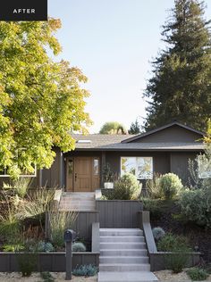 a house that has steps leading up to the front door and entry way with trees in the background