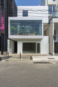 an empty parking lot in front of a building with lots of glass on the windows