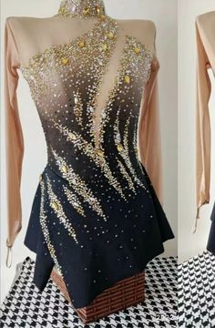 the back of a dress with gold and black sequins on it, sitting on a checkered tablecloth