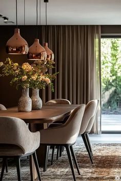 a dining room table with chairs and vases on it