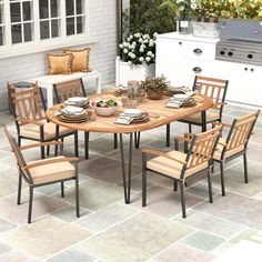 an outdoor dining table with chairs and plates on it