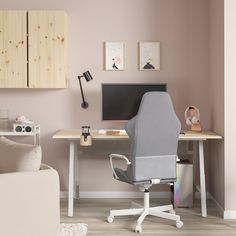 a computer desk with a monitor, keyboard and mouse on it in a pink room