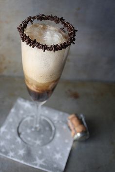 a glass filled with ice cream and chocolate sprinkles sitting on top of a metal tray