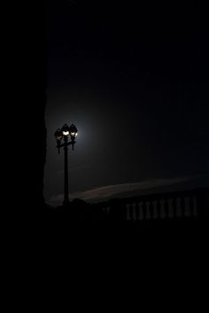 a street light sitting on the side of a road at night