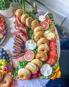 a platter filled with sandwiches, fruit and meats on skewered skewers