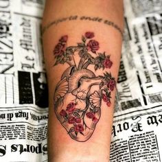 a tattoo on the leg of a woman with flowers and a heart shaped vase in it