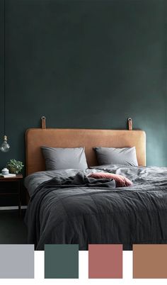 a bedroom with dark green walls and grey bedding, along with neutral colors in the room