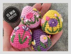 small crocheted balls with flowers on them in the palm of someone's hand