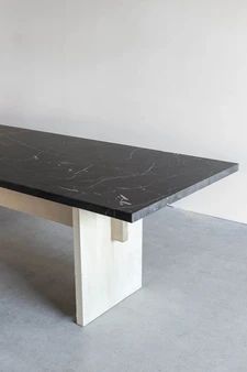 a black and white marble table in an empty room