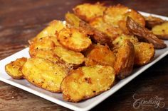 fried potatoes on a white plate sitting on a wooden table