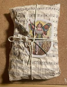 a piece of paper with an angel on it and sheet music notes tied to it