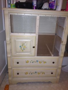 an old dresser with birdcage doors and flowers painted on the bottom drawer is shown