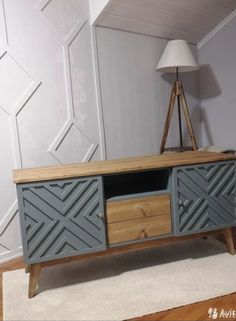 an entertainment center with two drawers and a lamp