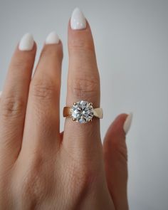 a woman's hand with a diamond ring on it