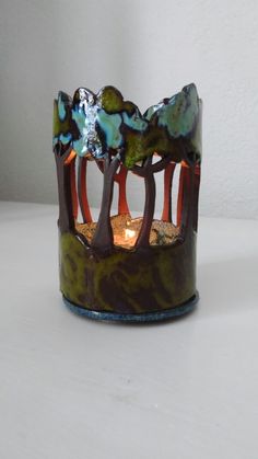 a decorative candle holder with trees on it