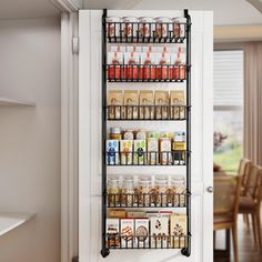 a pantry rack with spices and condiments hanging on the wall next to a dining room table