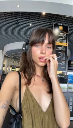 a woman wearing headphones standing in an airport