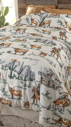 a bed covered in a white and brown cow print comforter