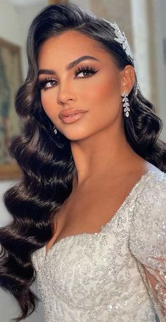 a woman with long hair wearing a tiara and diamond headpiece, looking off to the side