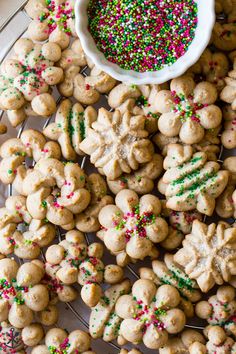 cookies and sprinkles are arranged on a cooling rack